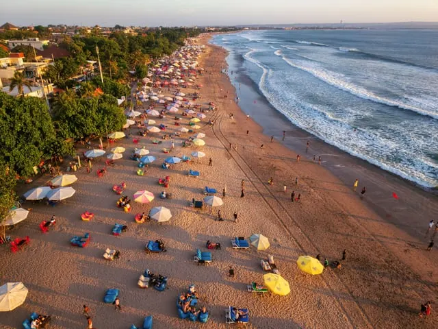 Tom Fisk / Pexels / Pexels Licence Kuta beach with umbrellas and surf, from above (people far off)