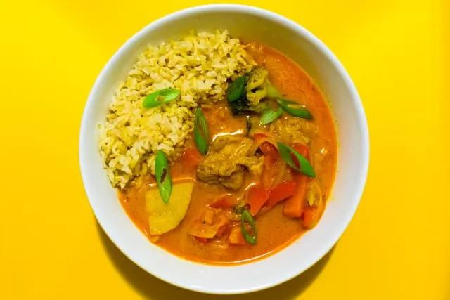 A red coconut curry with yellow rice (only 1920 px wide)