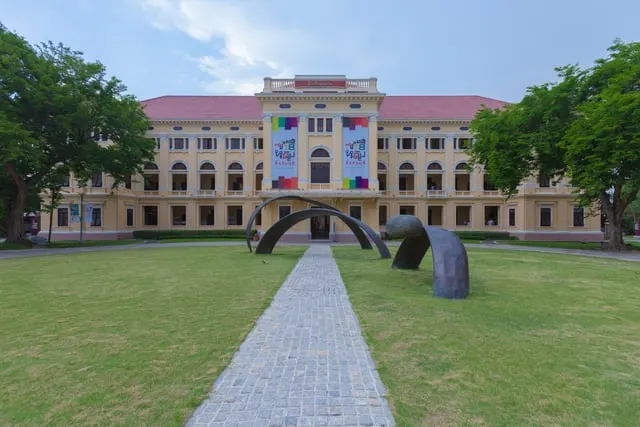 Supanut Arunoprayote, CC BY 4.0, via Wikimedia Commons The Museum of Siam building across its lawn, blue sky