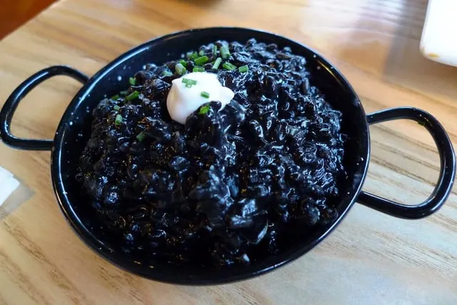 Black rice with cuttlefish in an iron pan