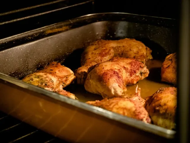 Seasoned roast chicken pieces in a tray