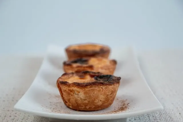 Egg tarts lined up on a white dish