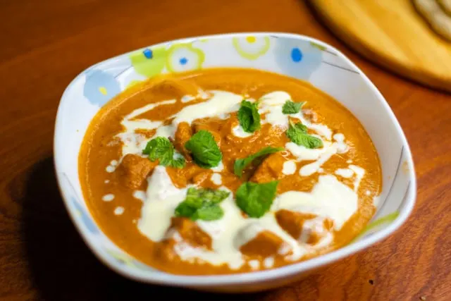 Butter chicken with mint and cream in a bowl