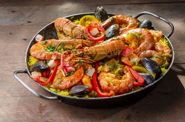 Seafood rice with prawns, langoustines and mussels in the pan