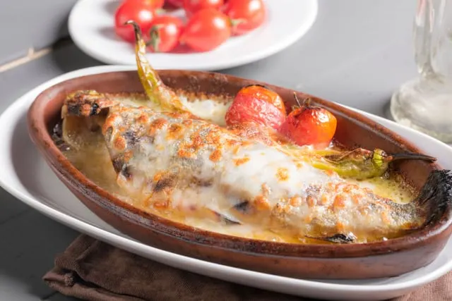 Baked fish in an earthenware dish with tomato (stand-in for turbot)