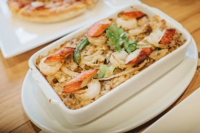 Baked rice with prawns in a white dish