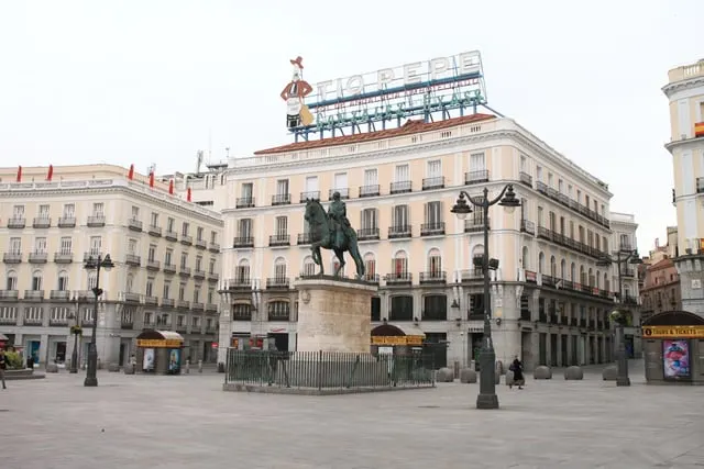Puerta del Sol's horse statue and the Tío Pepe sign, bright sky