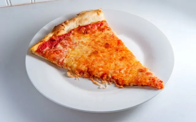 Single slice of cheese pizza on a white plate