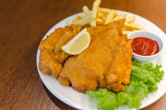 Golden schnitzel with fries, lemon and salad
