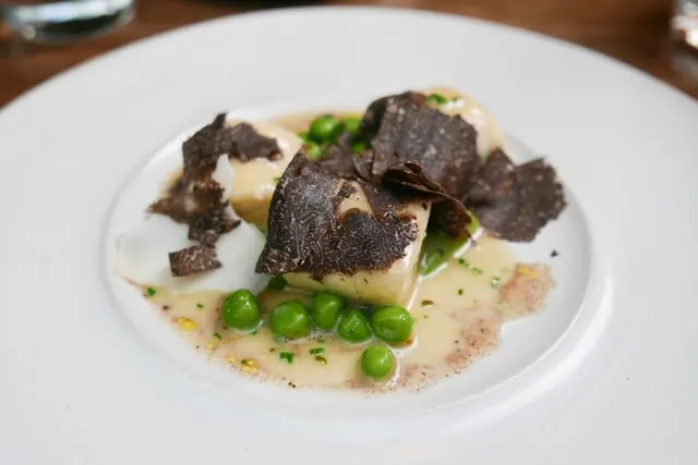 Ricotta dumplings with black truffle and peas