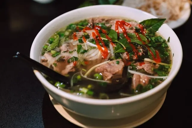 Beef pho with chilli sauce and greens