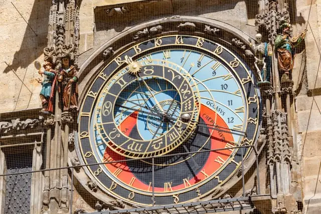 The clock's two dials and saint figures, sunny
